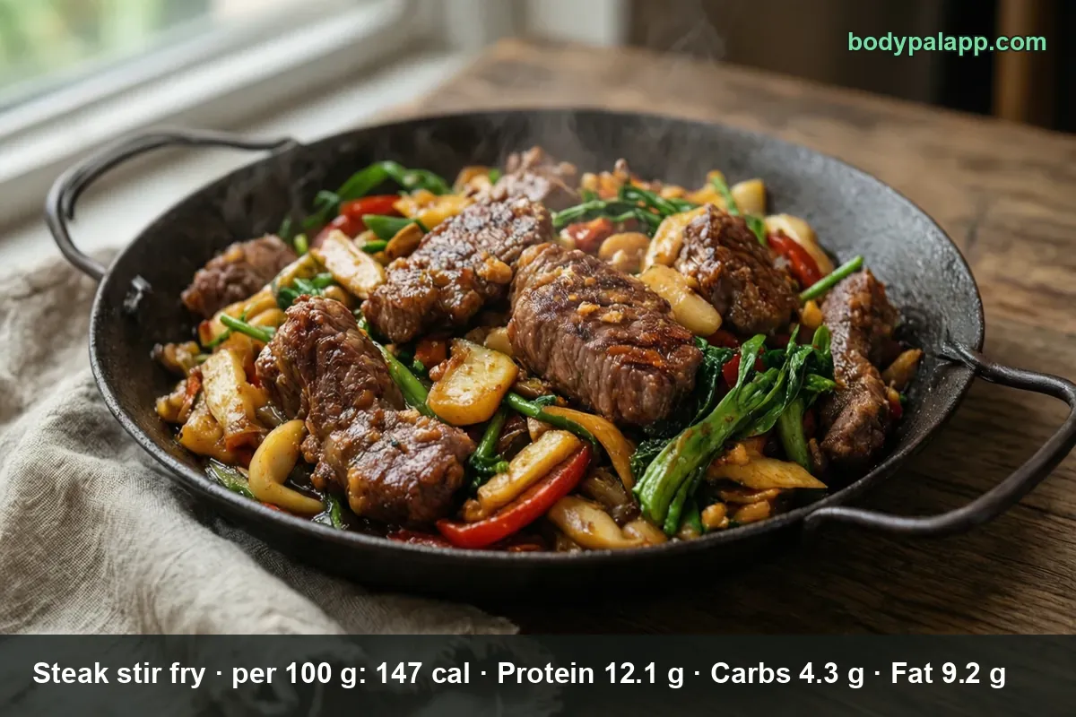Steak stir fry in a wok, strips of beef with peppers and vegetables, steam rising