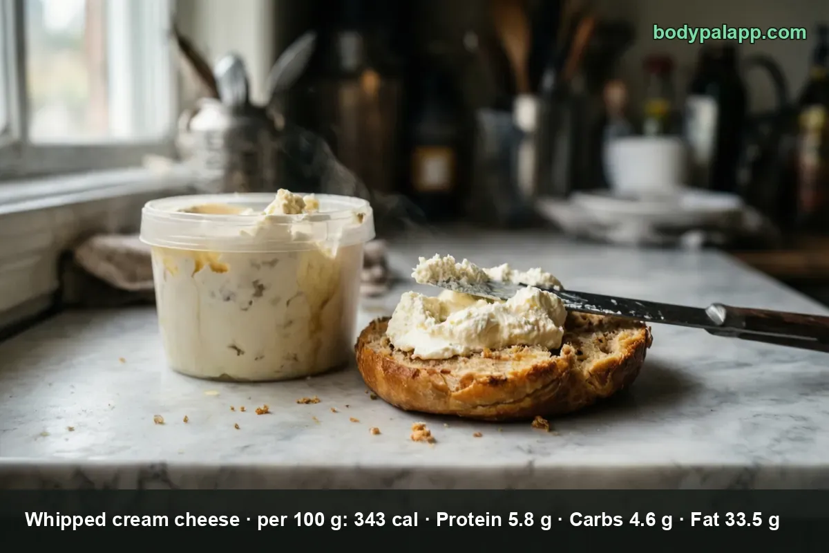 Open plastic tub of whipped cream cheese beside half a bagel spread with it and a knife